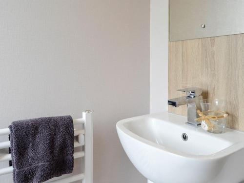 uma casa de banho com um lavatório branco e um espelho. em Kipp Away em Kippford