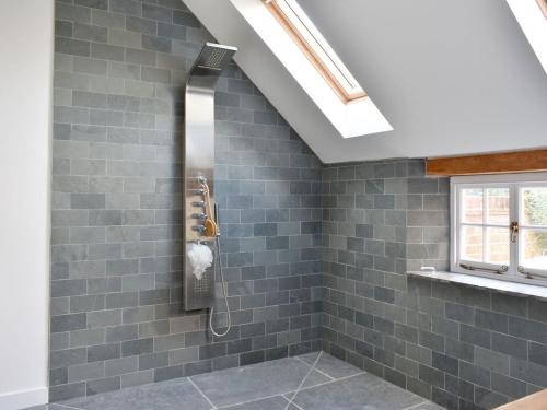 a bathroom with a shower with gray tiles at Oasis in Bradwell on Sea