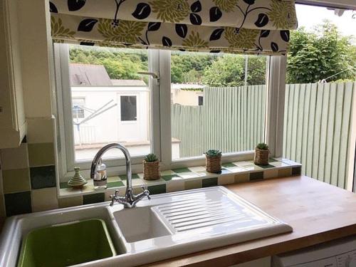 a kitchen counter with a sink and a window at Islas Cottage in Ystradgynlais