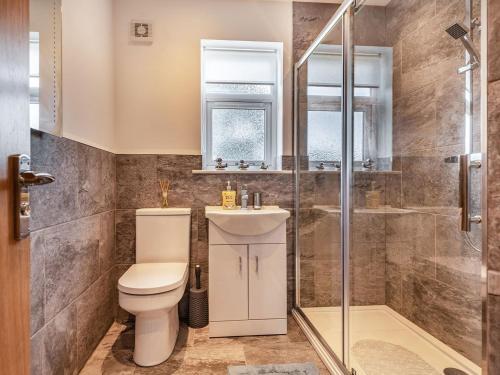 a bathroom with a toilet and a shower at Sycamore Lodge in Chapel Saint Leonards