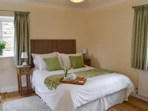 a bed with a tray with two teddy bears on it at The Gin Gan Cottage in Ryal