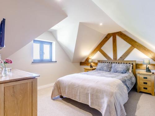 a bedroom with a king sized bed in a attic at The Old Dairy in Shipton under Wychwood
