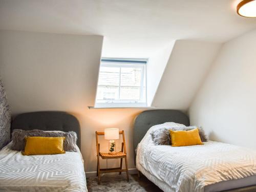 a bedroom with two beds and a window at The Photographers House in Southwold