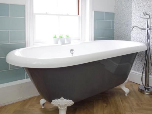 La salle de bains est pourvue d'une baignoire en noir et blanc. dans l'établissement The Photographers House, à Southwold
