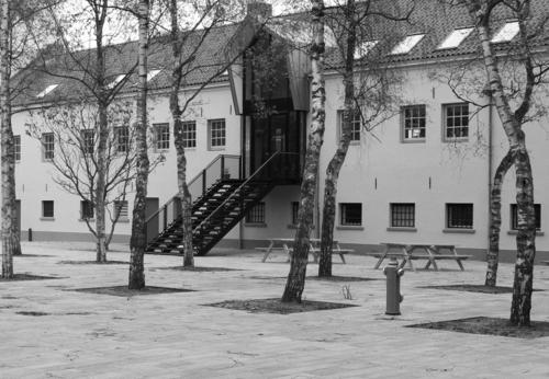 a black and white photo of a building with trees at Hotel Oostereiland in Hoorn