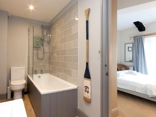 a bathroom with a sink and a toilet and a bed at Aloft in Salcombe