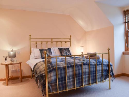 a bedroom with a bed with a blue and white blanket at Beech Walk in Crail