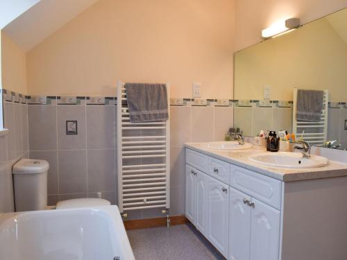 a bathroom with a sink and a toilet and a mirror at Beech Walk in Crail