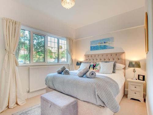 a bedroom with a large bed and windows at Kinbrae Apartment in Torquay