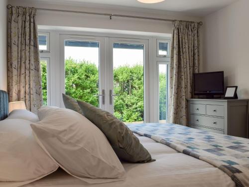 a bedroom with a bed with a large window at Southfield in Steventon