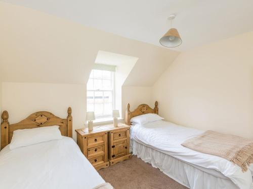 a bedroom with two beds and a window at Balnain 1 in Cononbridge