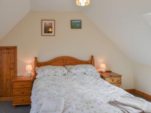 a bedroom with a bed with two night stands and two lamps at Dairy Cottage - Uk37833 in Pillaton