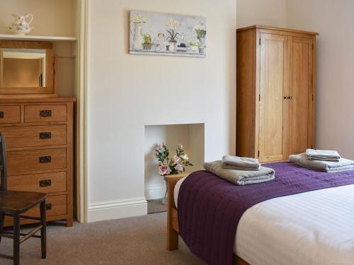 a bedroom with a bed and a wooden dresser at Arkle Terrace in Reeth