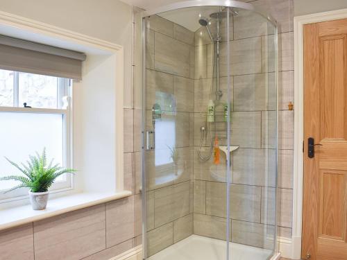 a shower with a glass door in a bathroom at Arkle Terrace in Reeth