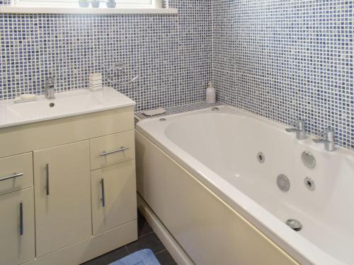 a bathroom with a tub and a sink and a bath tub at Haven View in Berwick-Upon-Tweed