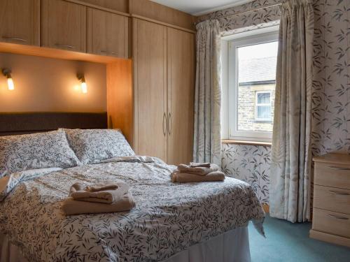 een slaapkamer met een bed met twee handdoeken erop bij Nidd Cottage in Pateley Bridge