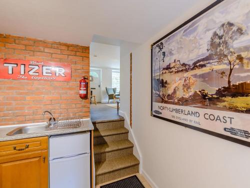 a kitchen with a sink and a movie poster on the wall at Millers Cottage in Belford