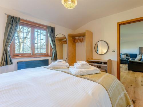 a bedroom with a large white bed with a mirror at Bluebell Lodge-uk32958 in Molash