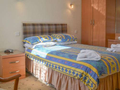 una camera da letto con un letto e asciugamani di White Gables - Uk30688 a Portknockie