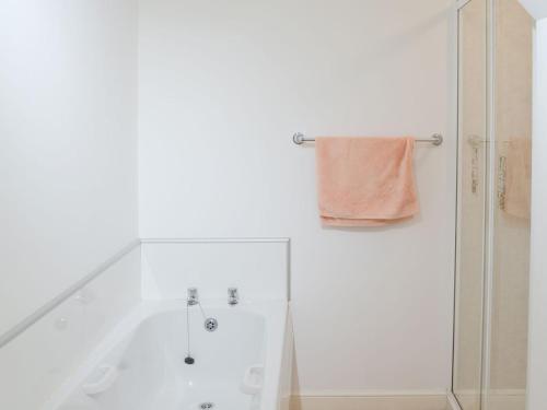 a white bathroom with a shower and a towel at White Gables - Uk30688 in Portknockie