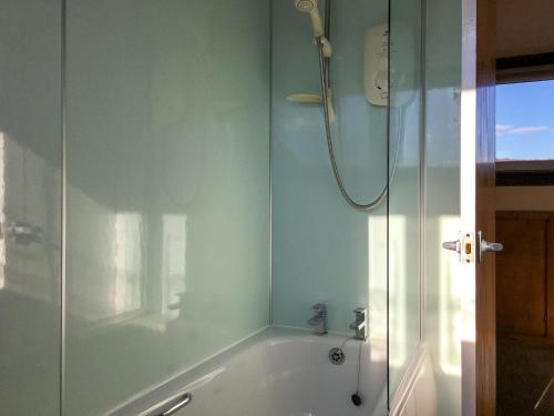 a bathroom with a shower and a bath tub at Wester Links in Fortrose