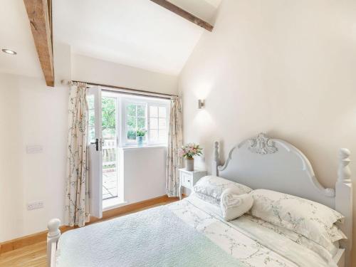 a bedroom with a white bed and a window at The Croft in Laneham