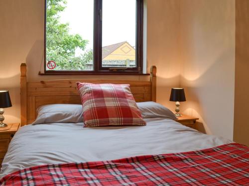 1 dormitorio con 1 cama con 2 lámparas y una ventana en Isleport Lodge en Highbridge