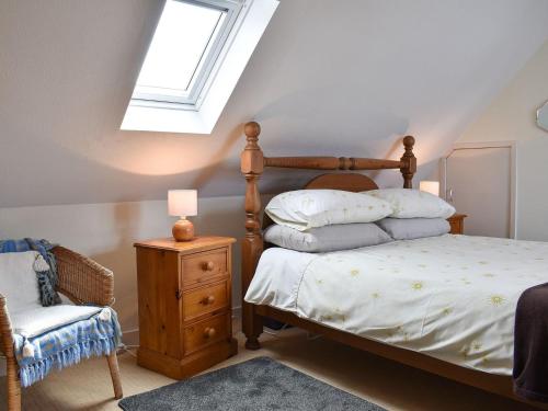 Tradewinds في Portknockie: غرفة نوم بسرير وكرسي ونافذة