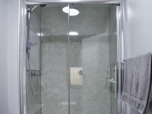 a shower with a glass door in a bathroom at Belger Cottage in Inverallochy