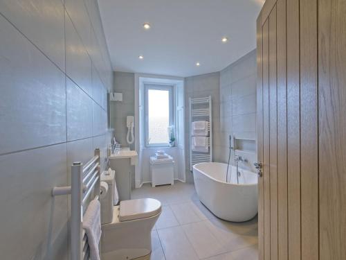 a bathroom with a tub and a toilet and a sink at Lower Canterbury House in Gattonside