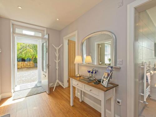 a bathroom with a vanity and a mirror and a door at Lower Canterbury House in Gattonside
