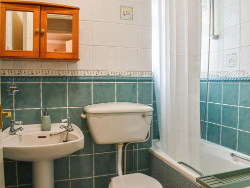 een badkamer met een toilet, een wastafel en een bad bij Melody in Bowness-on-Windermere