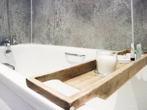 a bathroom with a bath tub with a glass of milk at 2 Mote View- Uk37496 in Sandhead