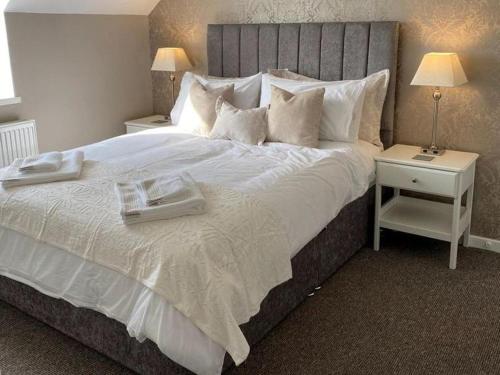 a bedroom with a large white bed with two trays on it at Neigwl View in Dinas