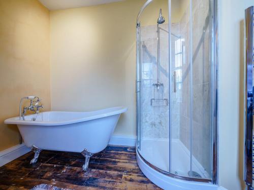Skenfrith的住宿－Malt House，带浴缸和玻璃淋浴间的浴室。