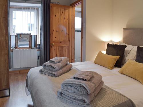 a bedroom with two beds with towels on them at Little Ingas Cottage in Strathmiglo