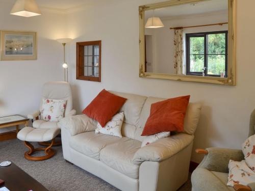 a living room with a white couch and a mirror at Gulls Nest in Morston