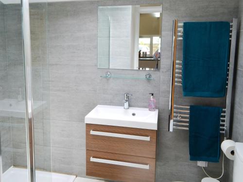 a bathroom with a sink and a shower with a mirror at The Studio At Westfield in Bellingham
