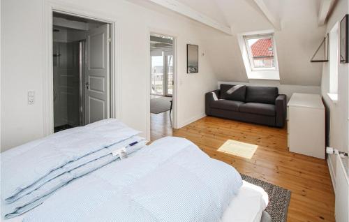 a white bedroom with a bed and a couch at Pet Friendly Home In Samsø With Wifi in Ballen