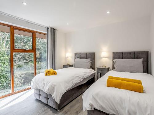 1 dormitorio con 2 camas y ventana en Waterside Lodge One - Uk33351 en Southowram