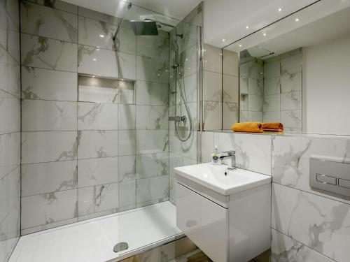 y baño blanco con lavabo y ducha. en Waterside Lodge One - Uk33351 en Southowram