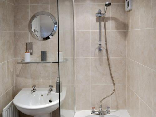 a bathroom with a shower and a sink at Chesterton Cottage in Miningsby