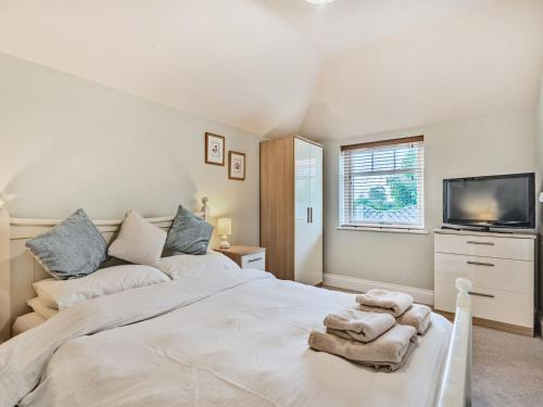 1 dormitorio con 1 cama blanca grande y TV en The Potting Shed - Uk36120 en Horsington