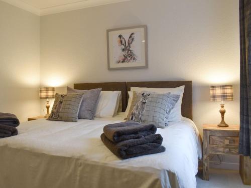 a bedroom with a bed with towels on it at West Lodge in Banchory
