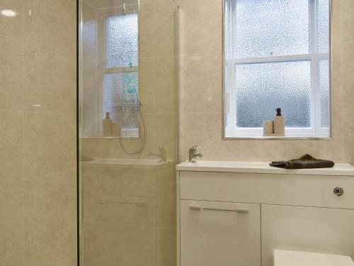 a bathroom with a shower and a sink at West Lodge in Banchory