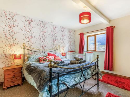 een slaapkamer met een bed met rode gordijnen en een raam bij The Threshing Barn - Uk35754 in Bideford