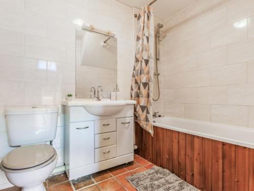 een badkamer met een toilet, een wastafel en een bad bij The Threshing Barn - Uk35754 in Bideford