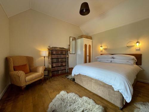 a bedroom with a large bed and a chair at Sheenas Butnben in Arnisdale