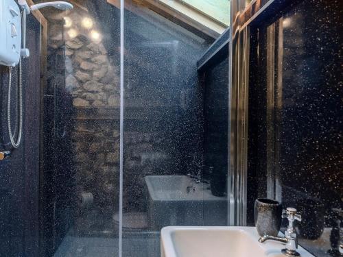 a bathroom with a glass shower and a sink at Honey Pots in Foulden