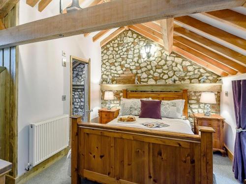 a bedroom with a large wooden bed in a building at Honey Pots in Foulden